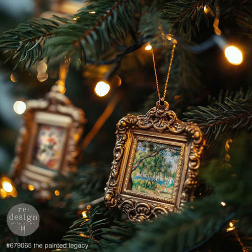 Redesign with Prima transfer A4 The Painted Legacy. Decorative Christmas ornament with gold frame and painting inside, hanging on a tree with lights.