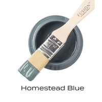Fusion Mineral Paint brush with a container of Homestead Blue paint on a white background