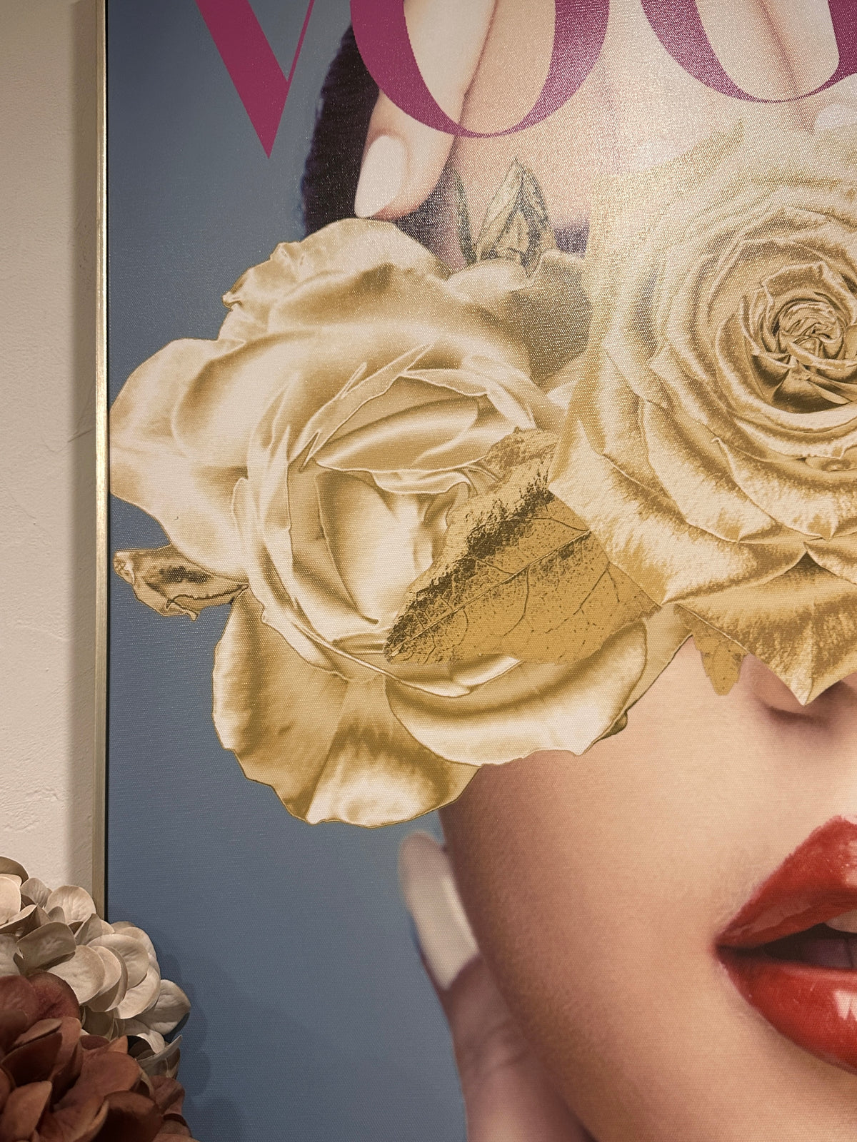 Close-up of a magazine cover with a woman's face partially obscured by gold roses. Vogue Canvas Framed