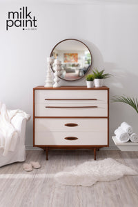White dresser with wooden accents in a room with 'milk paint' branding. Hotel Robe Fusion Milk Paint