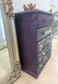 Purple dresser with Gothic-style doll with ram horns surrounded by dolls and butterflies. Dollmakers Curse Mulberry Decoupage Paper