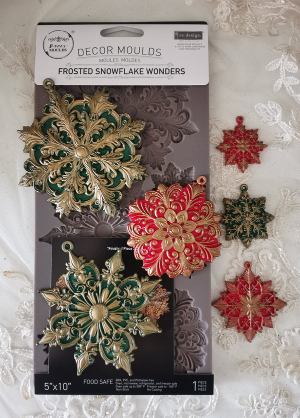 Decorative snowflake moulds on packaging with decorative snowflakes in the background Frosted Snowflake Wonders Mould by Redesign with Prima