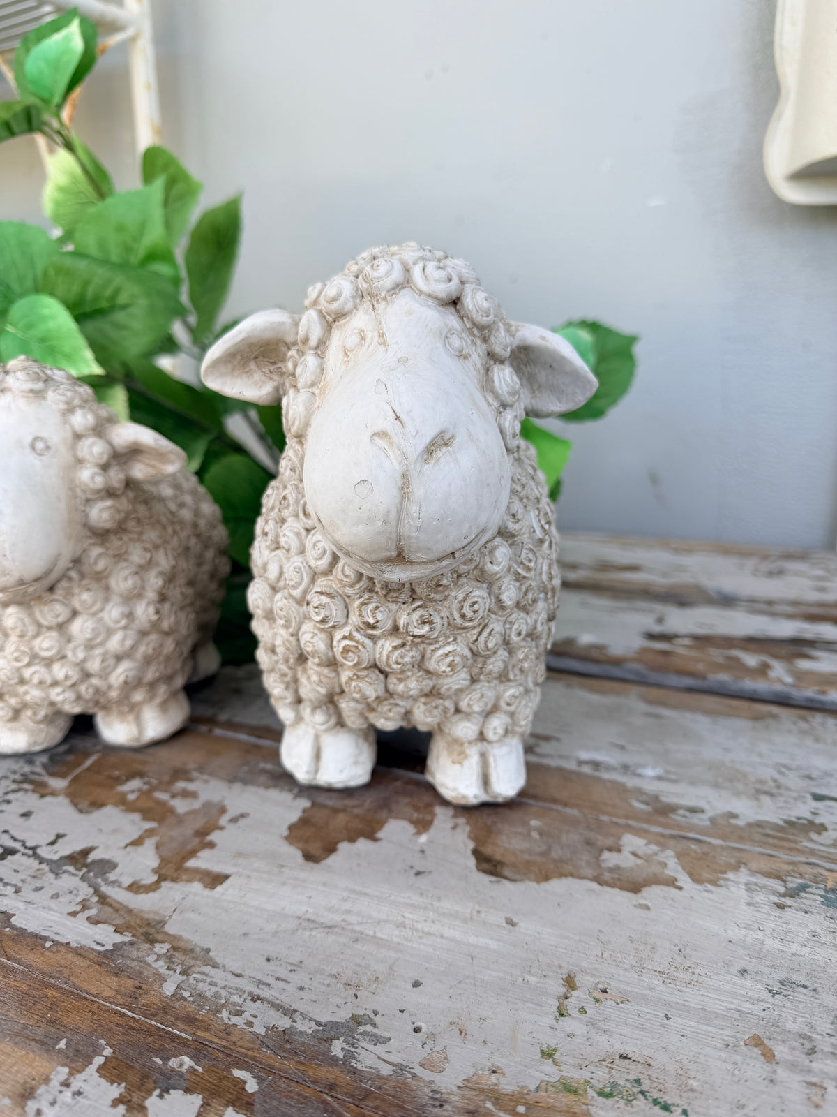 A small textured sheep figurine in a distressed off-white finish,