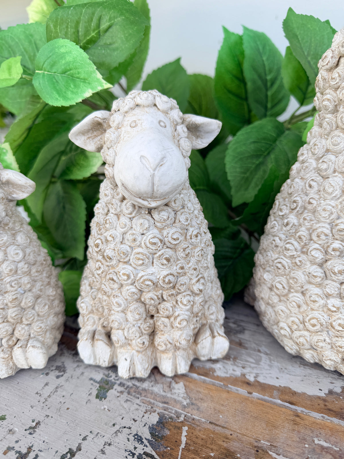 A small decorative sheep figurine with textured curly wool, shown sitting 
