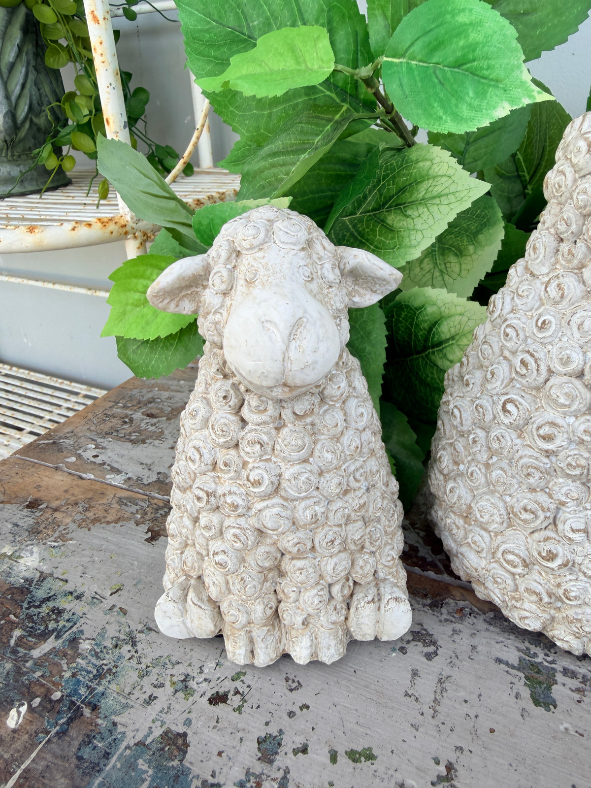 A small decorative sheep figurine with textured curly wool, shown sitting 