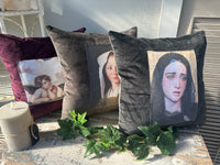 Decorative pillows with printed faces on a surface with greenery Velvet Cushion Midnight Mary II The Villa Collection