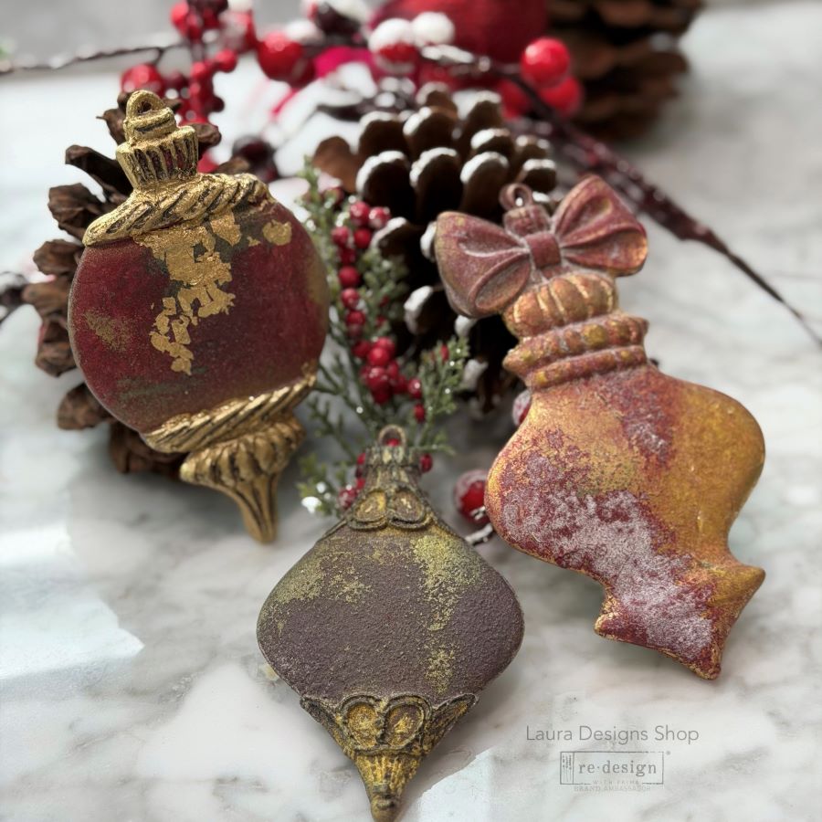 Decorative Christmas ornaments on a marble surface with pine cones and berries. Christmas Ornament mould set shown with the blank mold on the left and the cast  ornament pieces on the right. Winter Luxe Blanks Mould by Redesign with Prima