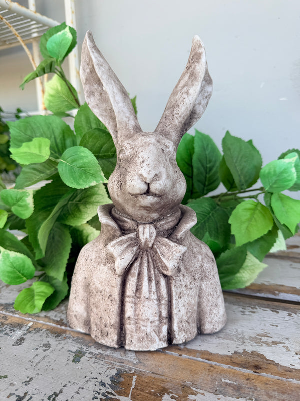 A stone-look rabbit figurine wearing a high collar and bow tie.