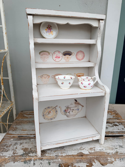 Decorative shelf with small ceramic items against a rustic wall. Tabletop Hutch Dresser