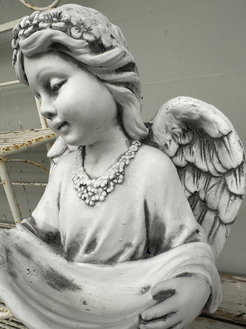 Statue of an angel with wings and a necklace Girl Angel Statue with swag background