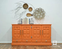 Orange cabinet with decorative items on a white wall, Tuscan Orange fusion mineral paint