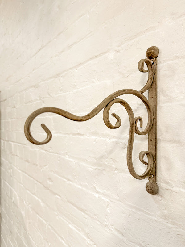 Decorative metal bracket on a textured white wall
