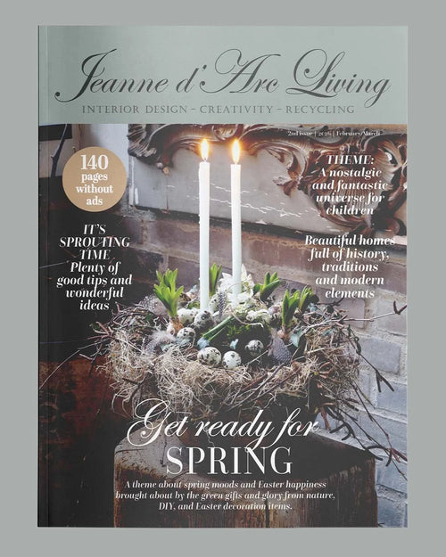 Magazine cover with candles and spring decorations, featuring 'Jeanne d'Arc Living' on a gray background. Issue 2 2026 Jeanne d'Arc Living Magazine