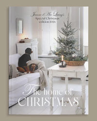 Magazine cover featuring a cozy living room with a Christmas tree and text about a special Christmas edition. Christmas Special 2026 Jeanne d'Arc Living Magazine