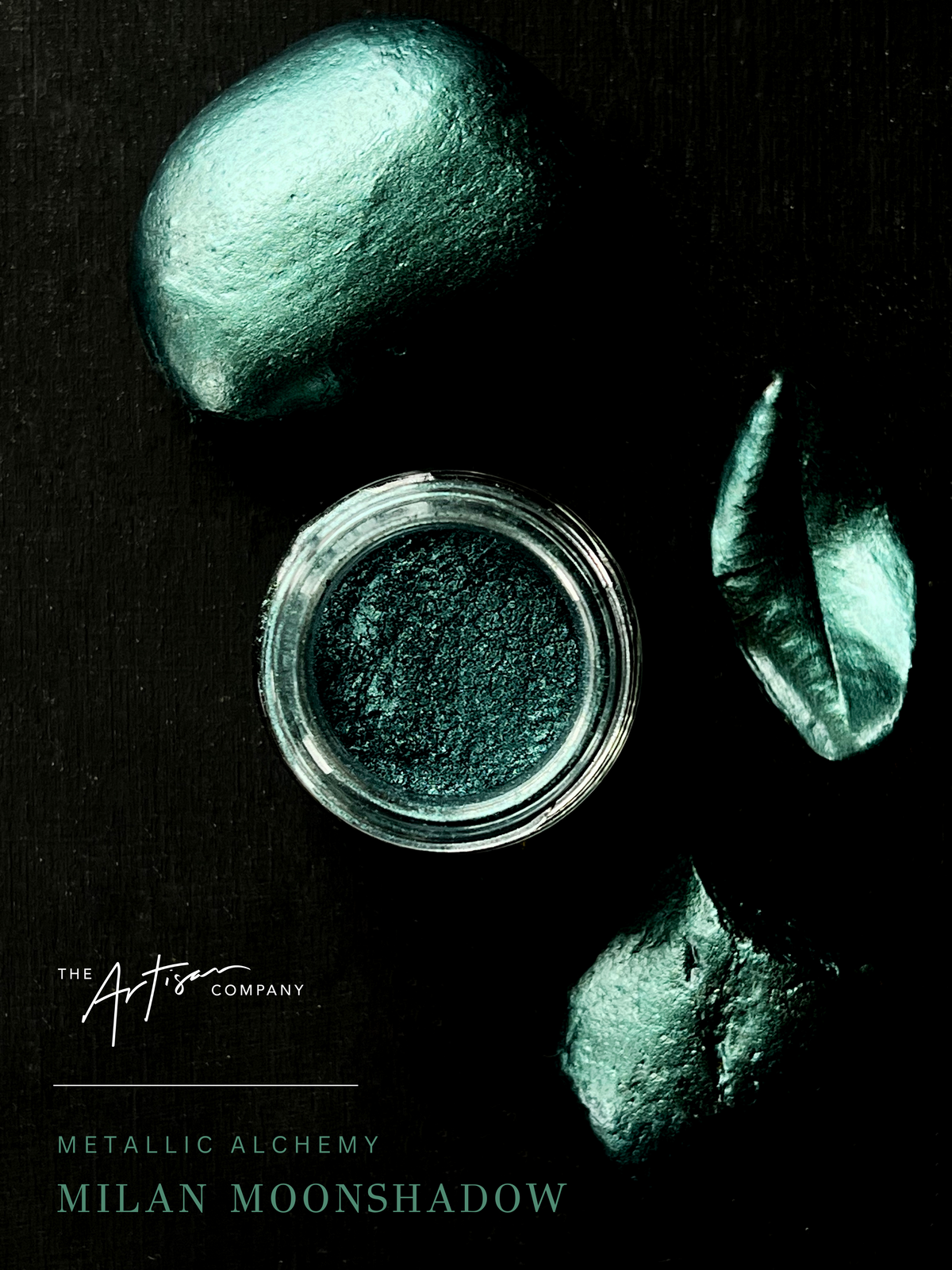 Jar of metallic powder with greenish-brown stones on a black background, featuring 'The Artisan Company' branding. Milan Moonshadow