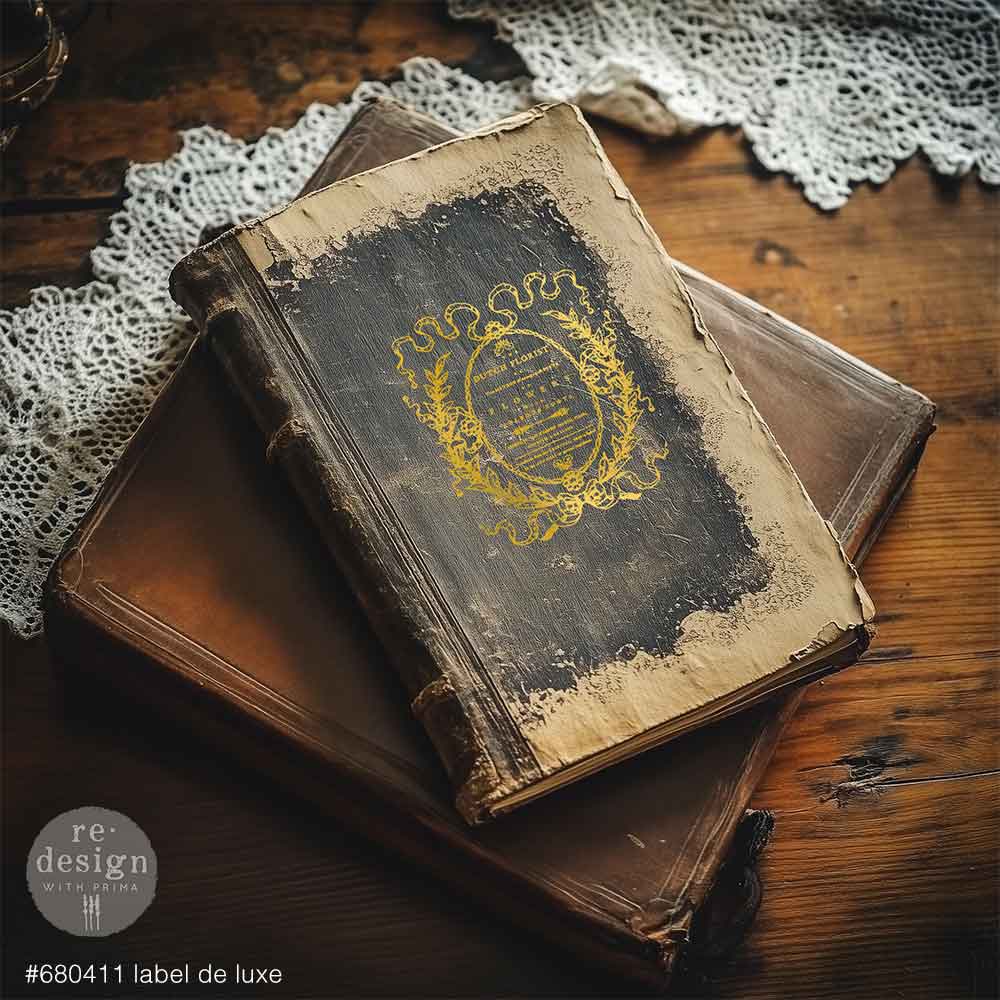 Redesign GOLD transfer Middy Label De Luxe KACHA. Vintage book with decorative cover on a wooden surface