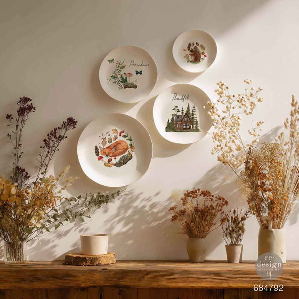 Decorative wall with plates featuring nature-themed designs. Redesign with Prima transfer middy The Forager's Retreat.