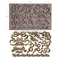 Decorative silicone mold with floral and bow designs on a white Timeless Ties Mould by Redesign with Prima background