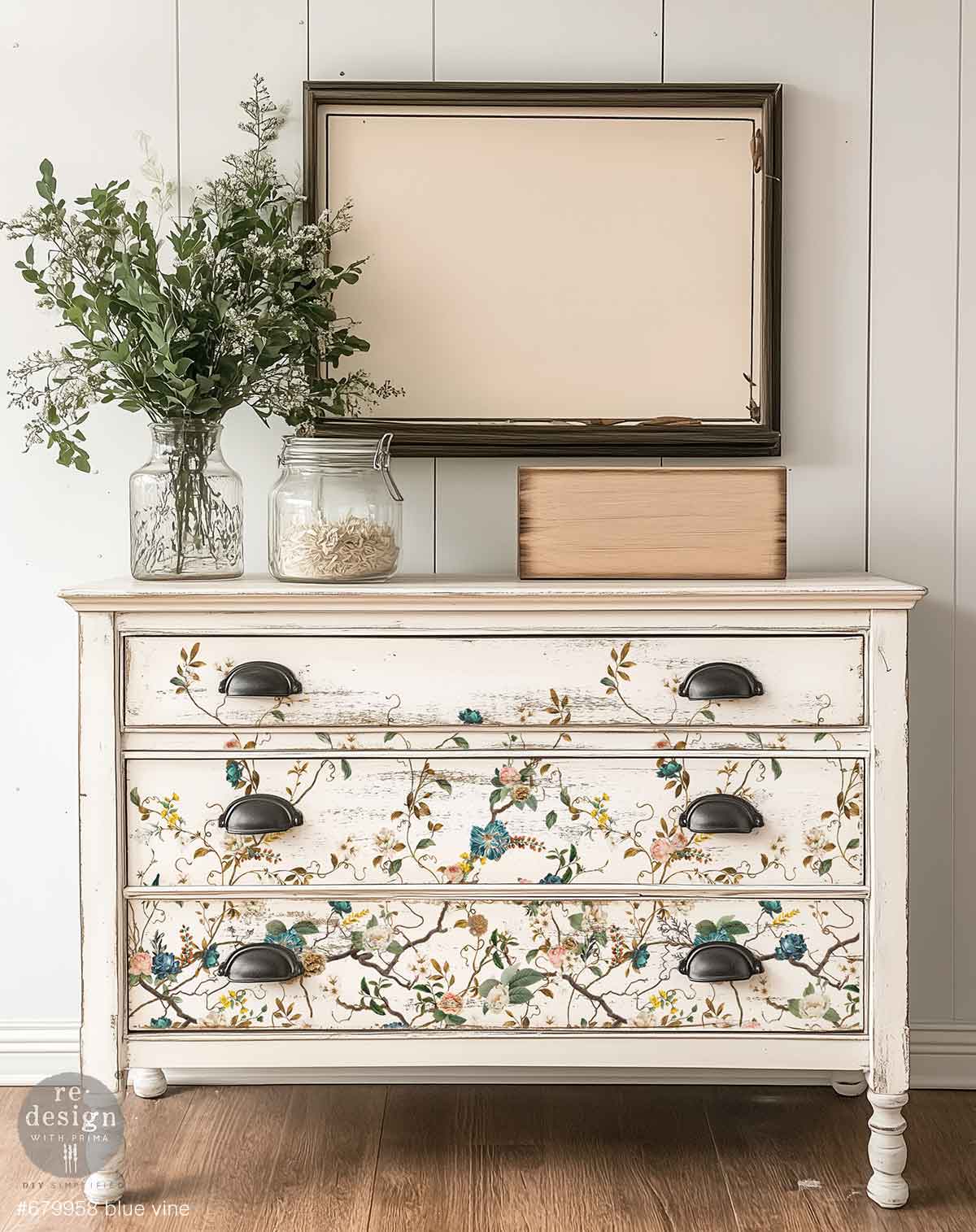 Redesign transfer Large Blue Vine Decorative dresser with floral patterns and black handles, placed against a white wall.
