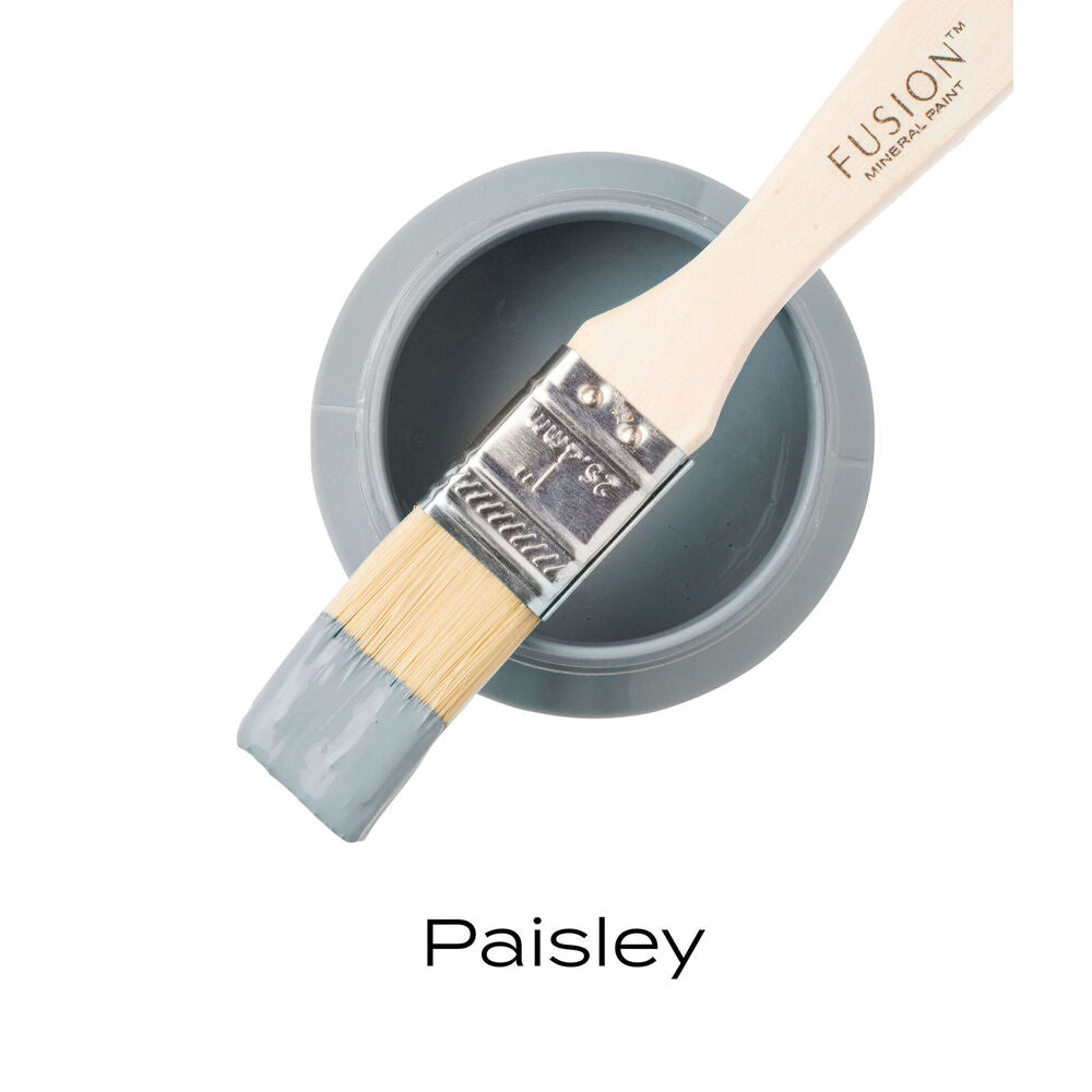 Fusion Mineral Paint can with a brush loaded with Paisley color on a white background