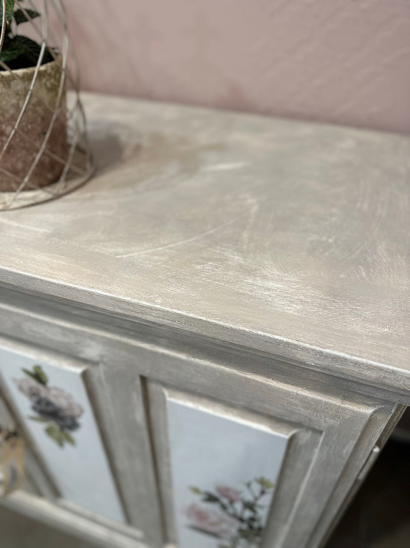 Using the Chateau method layering paint and wax has created this unique Olde Worlde look on this solid sideboard. Shades of grey, white and floral transfers complete the look, Dimensions approx 900mm height x 1200mm length.