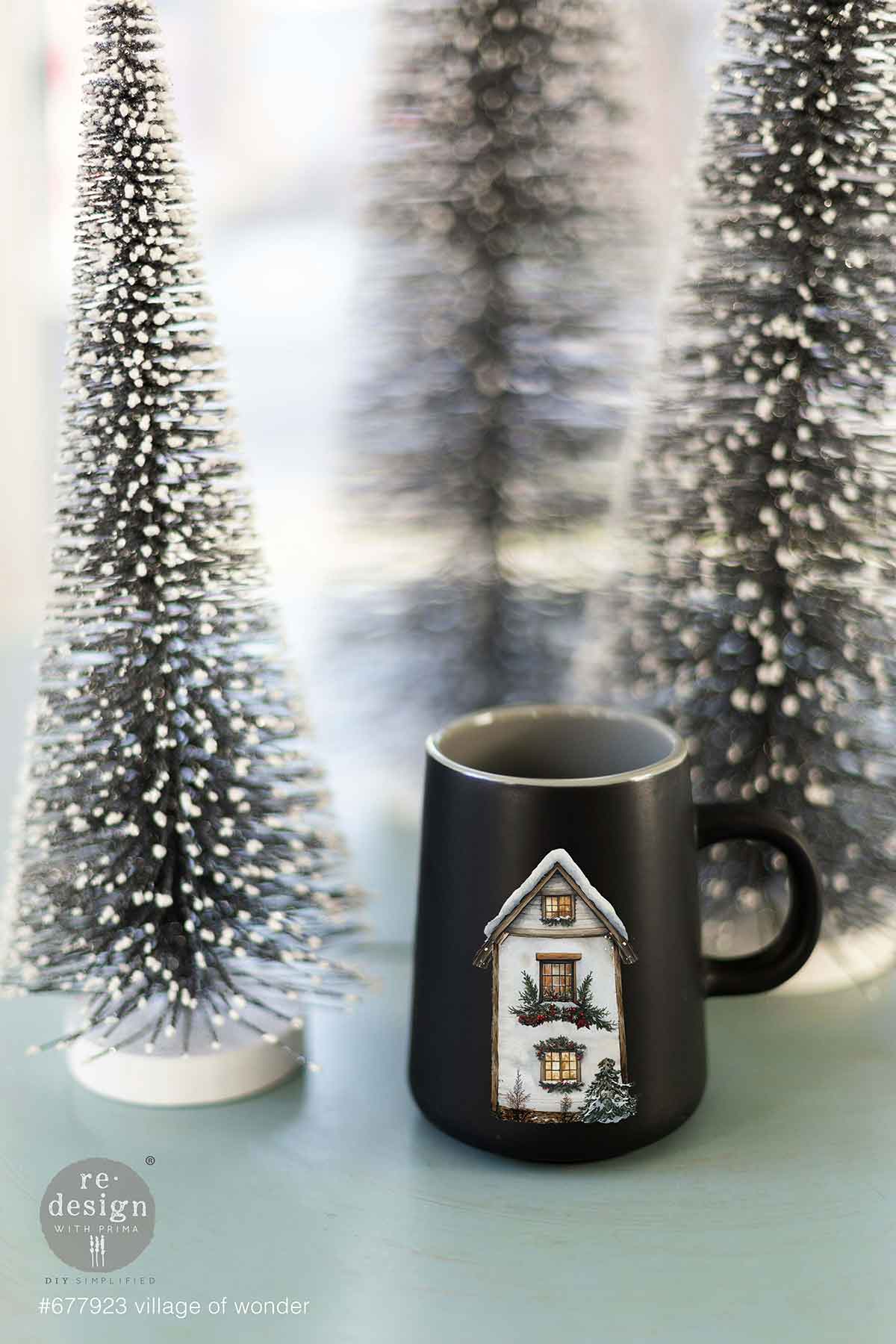 Redesign with Prima transfer middy Village of Wonder 4 sheet Black mug with house design on a light surface with decorative trees in the background